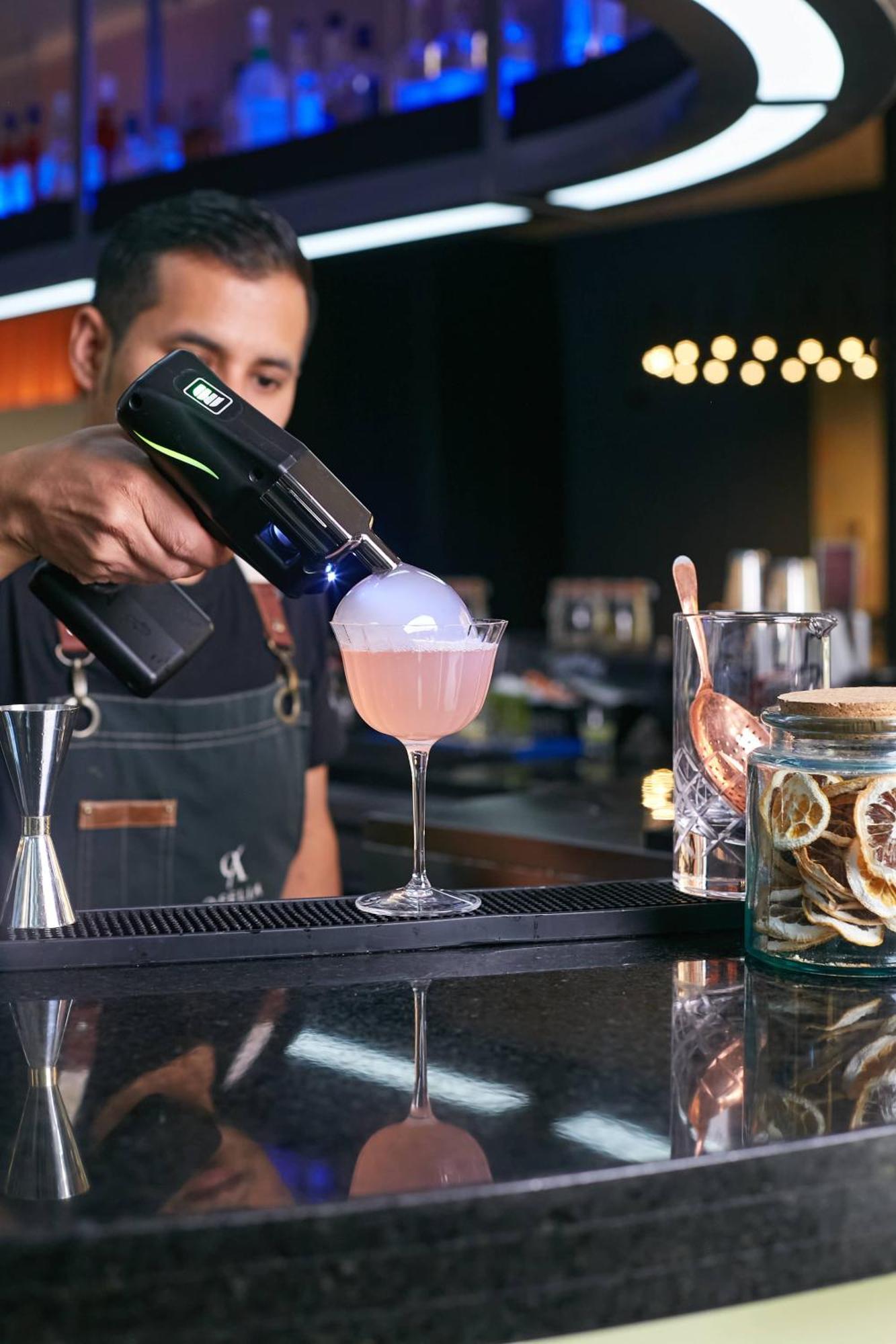 Pullman Santiago Vitacura Eksteriør billede A bartender using a blowtorch to cook a cocktail